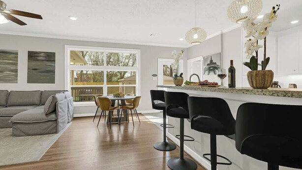 Eine moderne Küche mit Essbereich, Barhocker und Deckenventilator.