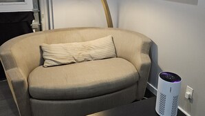 A living room with a sofa, a lamp, a coffee table, and a speaker. - New Modern Studio in Maryville (Maryville)