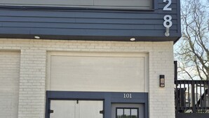 A two-story house with a garage door, a front door, and a staircase leading to the second floor. - New Modern Studio in Maryville (Maryville)