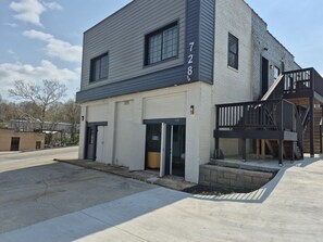 A two-story building with a garage, a staircase, and a small outdoor area. - New Modern Studio in Maryville (Maryville)