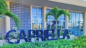 A building with large letters spelling 'CAPRIBIA' in the foreground, surrounded by greenery. - Luxury apartment in serena del mar (Cartagena)
