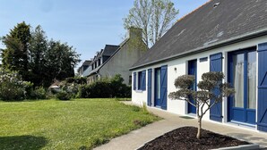 A building with blue shutters, a well-maintained lawn, and a small tree in the foreground. - TY BIHAN ☀️ (Crozon)