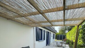 An outdoor patio with a sofa, chairs, and a table. - TY BIHAN ☀️ (Crozon)