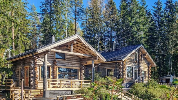 A log cabin with a porch, a small deck, and a staircase leading to the entrance. - Villa kaunisvirta by Interhome (Pyhtää)