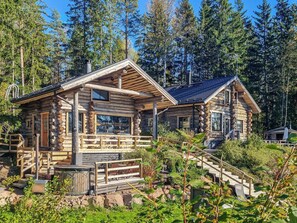 A log cabin with a porch, a small deck, and a staircase leading to the entrance. - Villa kaunisvirta by Interhome (Pyhtää)