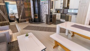 A modern kitchen with a large TV, wooden accents, and a fireplace.