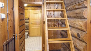 Un interior de madera con una escalera, una puerta y suelo de baldosas.