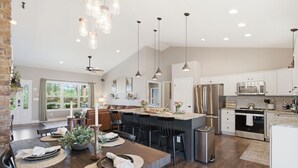 A spacious kitchen with modern appliances, a dining area with a large table, and a cozy seating arrangement.