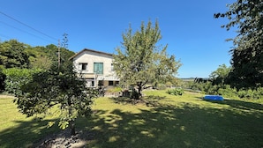 A house with a garden, a tree, and a blue inflatable pool.