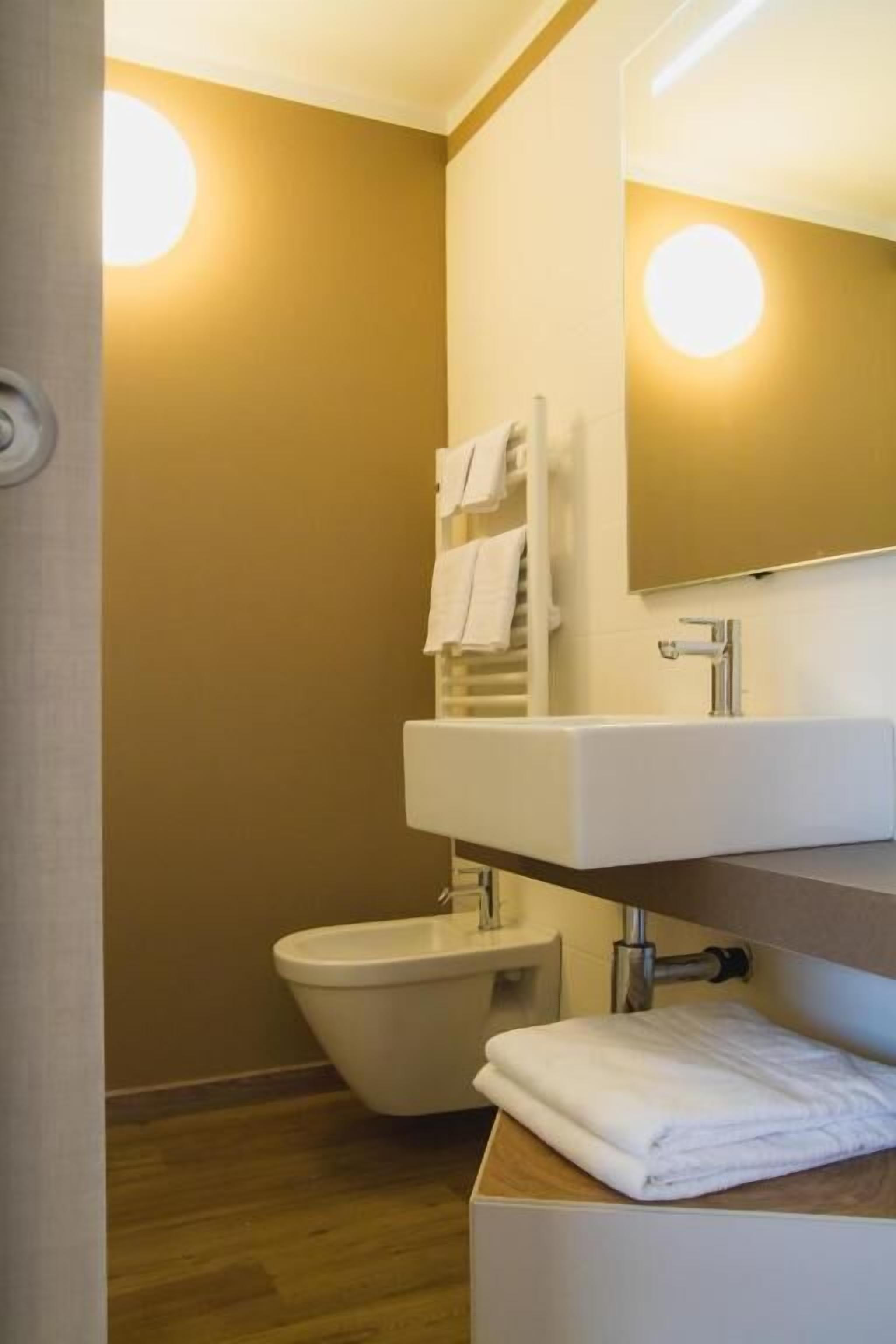 A bathroom with a white sink, a toilet, and a towel rack.