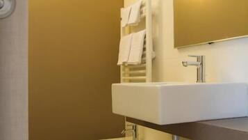 A bathroom with a white sink, a toilet, and a towel rack.