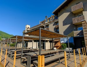 A modern building with outdoor seating and a covered patio area.