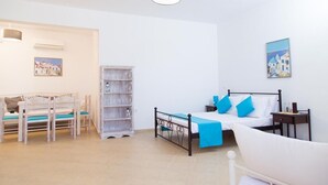 Una habitació amb un llit, una taula de treball, una cadira, una estanteria i un prestatge fixat a la paret.