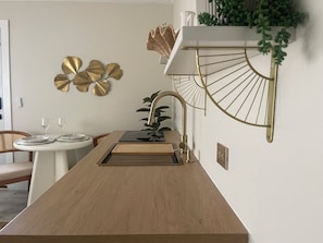 A modern kitchen with a wooden countertop, a sink, and a decorative wall piece. - Peaceful Boutique Suite • Private Entry • Near Beach & Downtown (Pensacola)