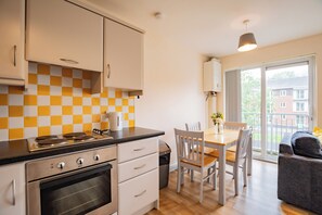 Une cuisine équipée d’une cuisinière, d’un four et d’un coin repas avec une table et des chaises.