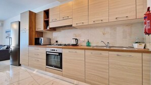 Una cocina moderna con armarios de madera, horno empotrado, microondas y estufa a gas.