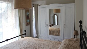 A bedroom with a bed, a wardrobe, a mirror, and a hanging lamp. - Accommodation surrounded by greenery, silence and privacy, a romantic escape from the city (Mozzano Torretta)