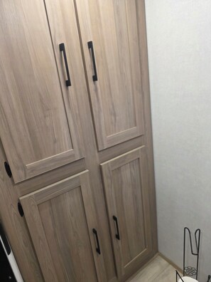 A wooden wardrobe with four doors and black handles. - 2025 Travel Trailer with Gazebo and Storage (Menifee)