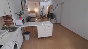 En modern lägenhet med kök, matplats och vardagsrum.