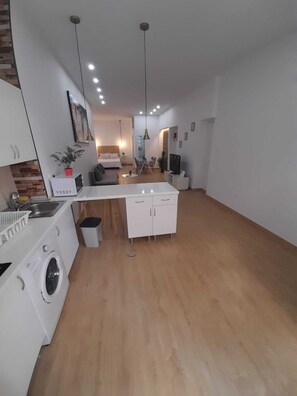 A modern apartment with a kitchen, dining area, and a living room. - Grilo Apartment (Málaga)