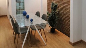 Ett modernt matområde med ett glasbord, stolar och en tegelvägg som accent.