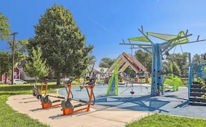 A playground with exercise equipment, a climbing structure, and a slide. - Lucas Oil Stadium - Modern Downtown Escape (Indianapolis)
