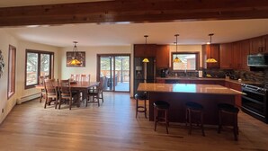 A spacious kitchen with a large island, wooden cabinets, and pendant lighting.