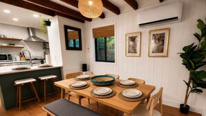A dining area with a wooden table set for four, surrounded by wooden chairs and a bench. - Pocono Basecamp | Hot Tub Chalet + Big Game Room (Tunkhannock Township)