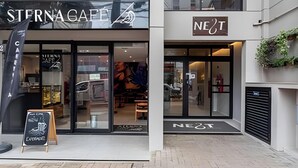 A storefront with 'STERNGAFF' and 'NE2T' signage, glass doors, and a brick-paved entrance. - Studio Elegance Next Pamplona (São Paulo)