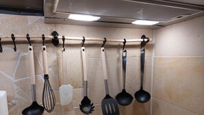 A kitchen with a hanging rack holding various utensils.