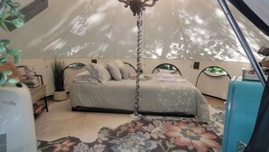 A tent with a bed, a chandelier, and a floral carpet. - Romantic night in nature. Yurt in Piedmont with AC/Heat (Piedmont)