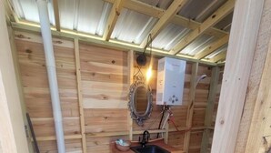 A wooden cabin with a wooden floor, a sink, a toilet, and a heater. - Romantic night in nature. Yurt in Piedmont with AC/Heat (Piedmont)