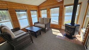 Eine Holzhütte mit Kamin, einer Couch und einem Tisch.