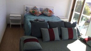 Une chambre à coucher avec un lit, une table de chevet et une fenêtre donnant sur un beau paysage.