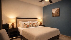 A hotel room with a bed, nightstands, a chair, a ceiling fan, and a wall-mounted picture. - La Hacienda Hotel - Mineral de Pozos (Mineral de Pozos)