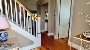 A staircase with wooden railings, a white door, a small table with a lamp, and a blue patterned rug. - 3-bedroom townhome in gorgeous St. Marys with Pool, Boat Ramp and Riverviews (St. Marys)
