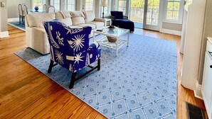 A spacious living room with a ceiling fan, large windows, a blue patterned rug, and a blue chair. - 3-bedroom townhome in gorgeous St. Marys with Pool, Boat Ramp and Riverviews (St. Marys)