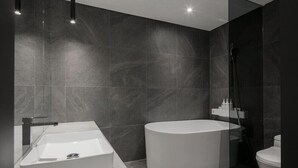 A modern bathroom with a rectangular sink, a freestanding bathtub, and a toilet. - H Hotel Wangsimni (Seoul)