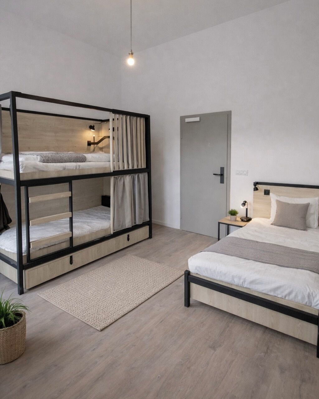 Een moderne slaapkamer met stapelbedden, een enkele bed, een nachtkastje met een lamp, en een kleine potplant.