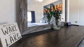 Et spejl med træramme og et skilt, hvor der står 'Bedre at vågne ved søen'.
