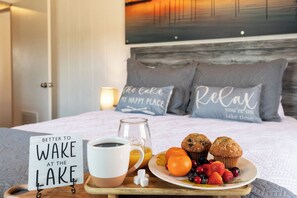Un lit bien fait, avec des oreillers, un plateau contenant des aliments pour le petit-déjeuner et un panneau sur le côté.