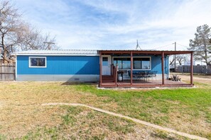 A single-story blue building with a covered porch and a small window.
