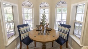 A dining area with a round table, four chairs, and a Christmas tree. - Near Bass Lake | Harley`s Hideaway Suite | Hot Tub (Oakhurst)