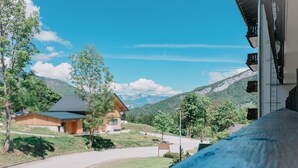 Blick auf Berge mit einem Holzhaus und einer Straße.