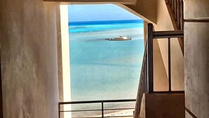 A view from a balcony with a railing, overlooking a calm sea and a small boat. - Your perfect Red Sea getaway at Hurghada. (Hurghada)