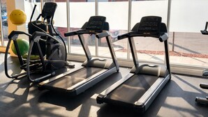 Kuntosali, jossa on juoksumattoja, kuntopyörä ja crosstrainer.