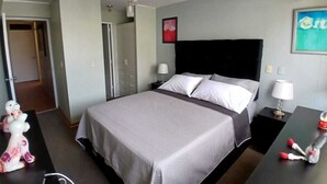 A hotel room with a bed, bedside tables, a wardrobe, a door, and a wall with a picture. - Apartamento Ideal en Zona Centrica (Jesús María)