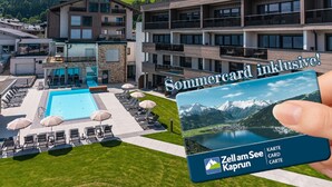 Ein modernes Gebäude mit Pool, Liegestühlen und Sonnenschirmen.