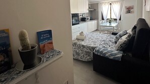 Um apartamento moderno com sala de estar, cozinha compacta e espaço para refeições.