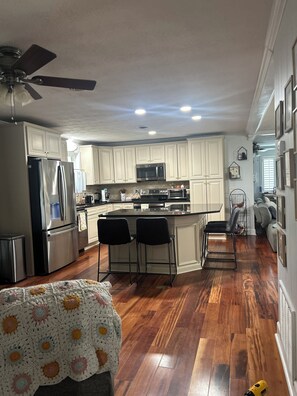 A kitchen with white cabinets, a refrigerator, microwave, and a ceiling fan. - Lovely 4-Bedroom, Close to everything including Augusta Nationals (Martinez)